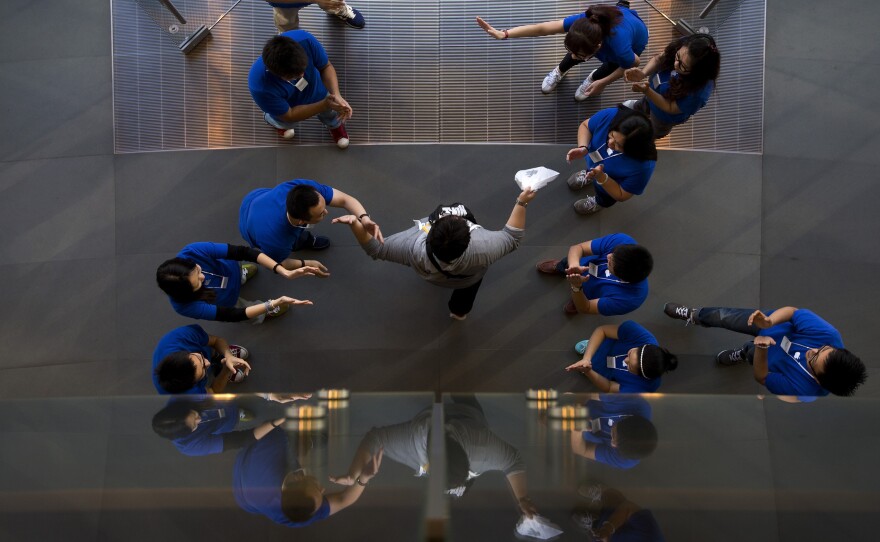 Apple says it has sold 9 million iPhone 5s and 5c models since their launch on Friday. Here, staff members at an Apple retail store in Beijing cheer a customer after he bought a new iPhone.