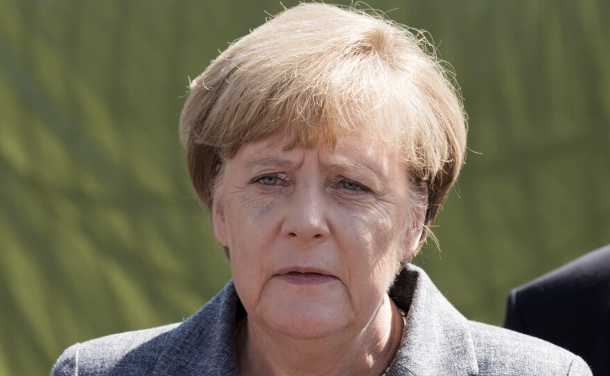 German Chancellor Angela Merkel addresses journalists on Wednesday after visiting a refugee shelter in Heidenau, eastern Germany, attacked by far-right protesters over the weekend.