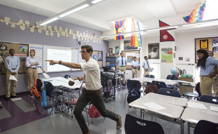 On the first day of school, Taylor Delhagen assigns his ninth-grade students to write "Tweets" about Michael Brown's killing in Ferguson, Mo., based on different depictions of events he posted around the room.