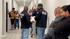 Several Immigration and Customs Enforcement (ICE) agents stand in the hallway of San Diego's immigration court, waiting to detain people as they exit their court hearings on Thursday May 22, 2025.