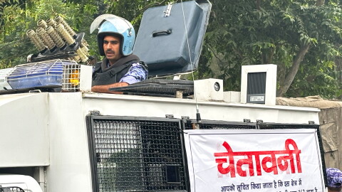 An armored vehicle with a banner warning citizens against unlawful gathering stands near the venue of a youth protest demanding the resignation of the country's election chief Gyanesh Kumar, in New Delhi, India, Saturday, Oct. 10, 2026. (AP Photo/Manish Swarup)