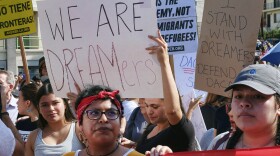 Supporters of the Deferred Action for Childhood Arrivals, or DACA chant slogans and hold signs while joining a Labor Day rally in downtown Los Angeles on Monday, Sept. 4, 2017.