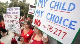 Karman Willmer, left, and Shelby Messenger protest against a measure requiring California schoolchildren to get vaccinated in Sacramento, June 9, 2015.