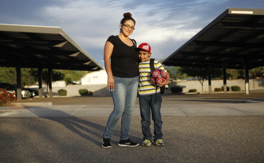 Humberto and his mother, Zaira Yanez, pose for a portrait outside his school. Not knowing english, she says, sometimes keeps her from helping Humberto more.