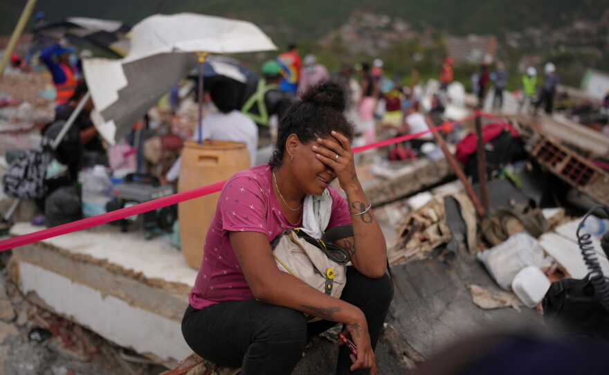 Khaterine Roa cries as members of the Los Angeles County Fire Department search for survivors at a building that collapsed during the earthquakes that struck La Guaira, Venezuela, Tuesday.