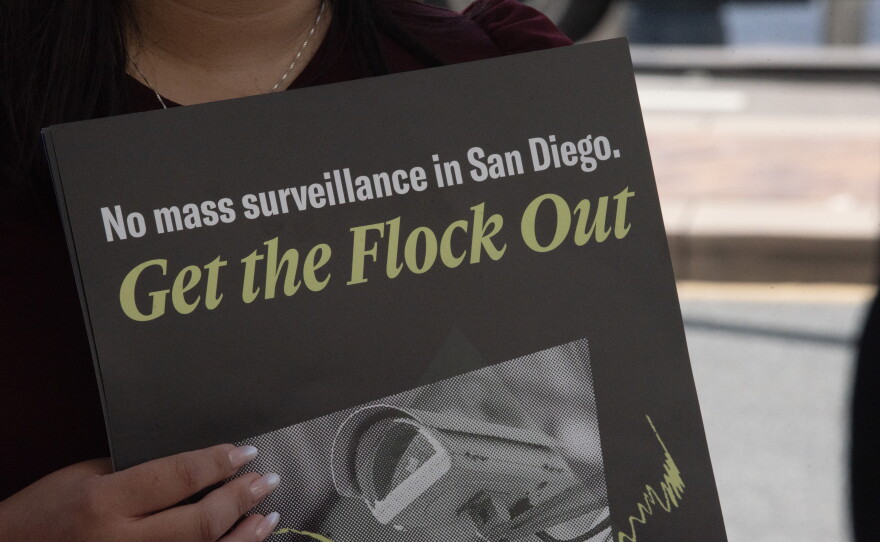 A protester holds a sign at a press conference announcing a lawsuit over the city of San Diego's use of Automated License Plate Reader technology on Sept. 30, 2026.