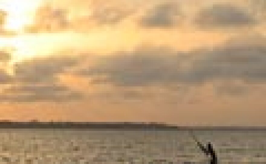 Epe Ekpe revelers take a dugout canoe across Lake Togo at sunset.