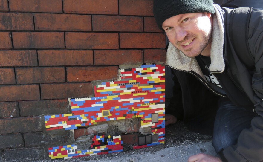 Nate Swain poses for a photo by his artwork.
