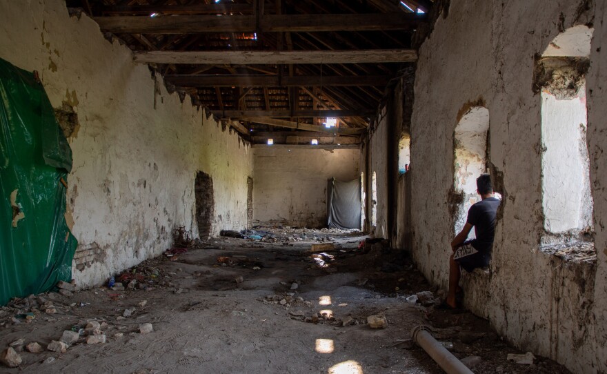 A man from Afghanistan sits in an abandoned farm building on the outskirts of the Serbian village of Horgos, along the Hungarian border. He says that when Hungarian authorities apprehended him on the border, they forced him to stand for 10 hours, threatening to unleash snarling dogs on him.