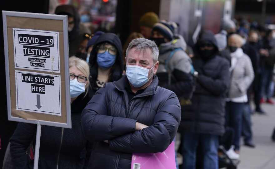 People wait in line at a COVID-19 testing site in Times Square, New York, Monday, Dec. 13, 2021.