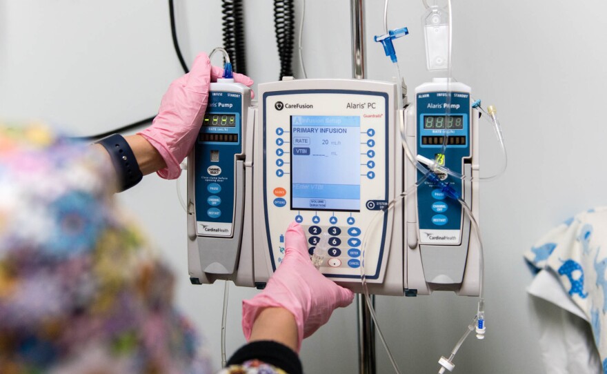 The nurse programs a pump to administer Luke Whitbeck's enzyme-replacement therapy in October 2016.