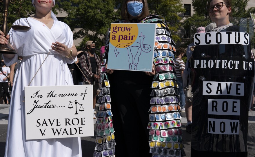 Activists hold signs during the Women's March rally at Freedom Plaza in Washington on Saturday.