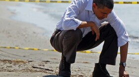 President Obama picks up balls of tar while touring the beach in Port Fourchon, La., on May 28.