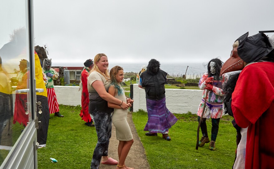 Tristan da Cunha's Head of Tourism, Kelly Green, greets the Okalolies with her daughter Savanna after they've arrived at their home. Moments after this image was taken, Kelly was soaked with water from a garden hose. Kelly's husband, Shane, was one of the Okalolies, and Kelly had trouble figuring out who her husband was before he finally revealed himself.