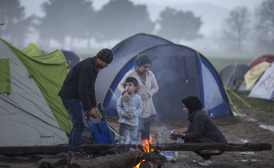 A family warms by a fire in the early morning on the Greek-Macedonia border on Tuesday in Idomeni, Greece.