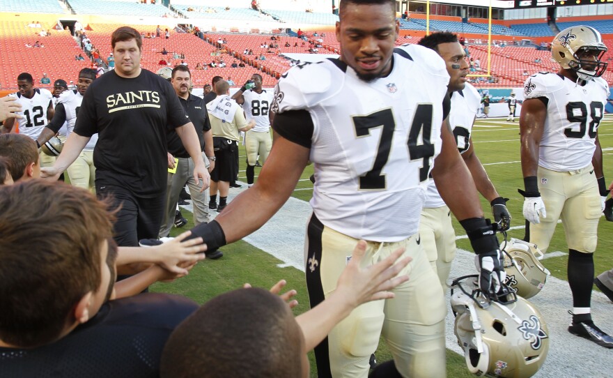 New Orleans Saints defensive end Glenn Foster Jr. greets fans before an NFL preseason game against Thursday, Aug. 29, 2013 in Miami Gardens, Fla. Foster died on Monday while in police custody.