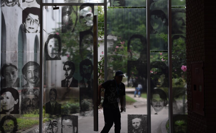 A visitor enters the Officers Casino building at ESMA on March 19, 2016. The windows are filled with images of civilians who were tortured and killed here.