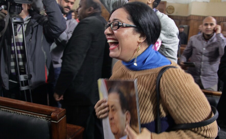 A supporter of ousted President Hosni Mubarak reacts in a courtroom to a verdict ordering a retrial in Cairo on Tuesday.