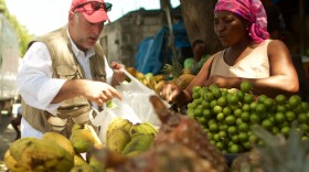José Andrés buys fruit from a local market in Port-au-Prince.