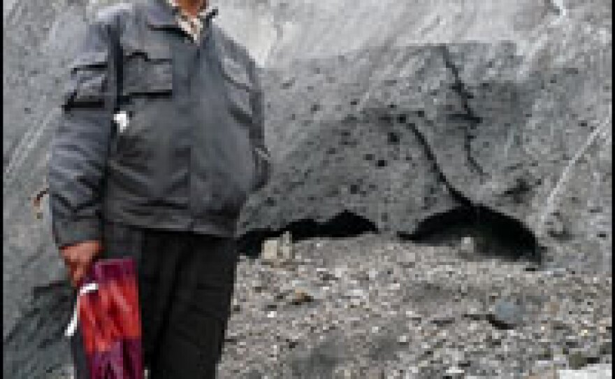 The chief of Mingyong village, Da Zhaxi, stands at the tip of the glacier. He says the villagers' forefathers believed the snow mountain, and its glacier, were essential for the village's continued existence.
