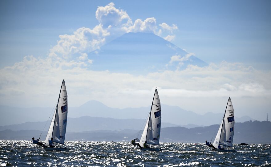 From left, Japan's Ai Yoshida and Miho Yoshioka, Britain's Hannah Mills and Eilidh Mcintyre and France's Aloise Retornaz and France's Camille Lecointre sail past Mount Fuji during the women's two-person dinghy 470 medal race on August 4.