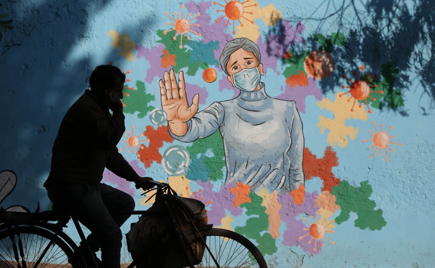 A mural in New Delhi is part of public health messaging in India. The country saw a dramatic decline in new cases since the peaks of fall 2020, but researchers aren't sure why.