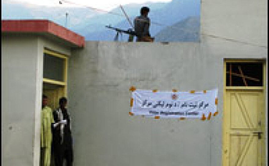 A policeman stands guard on the rooftop of a voter registration center in Shigal district of volatile Kunar province in eastern Afghanistan.