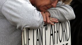 A supporter of health care reform leans on her sign during rally in Belgrade, Mont.