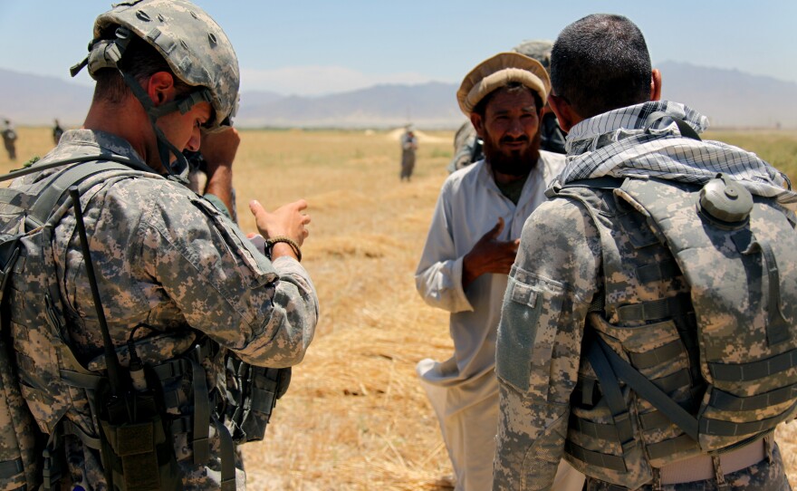 An Afghan interpreter (right) helps a U.S. soldier gather information from a local resident in this 2010 photo.