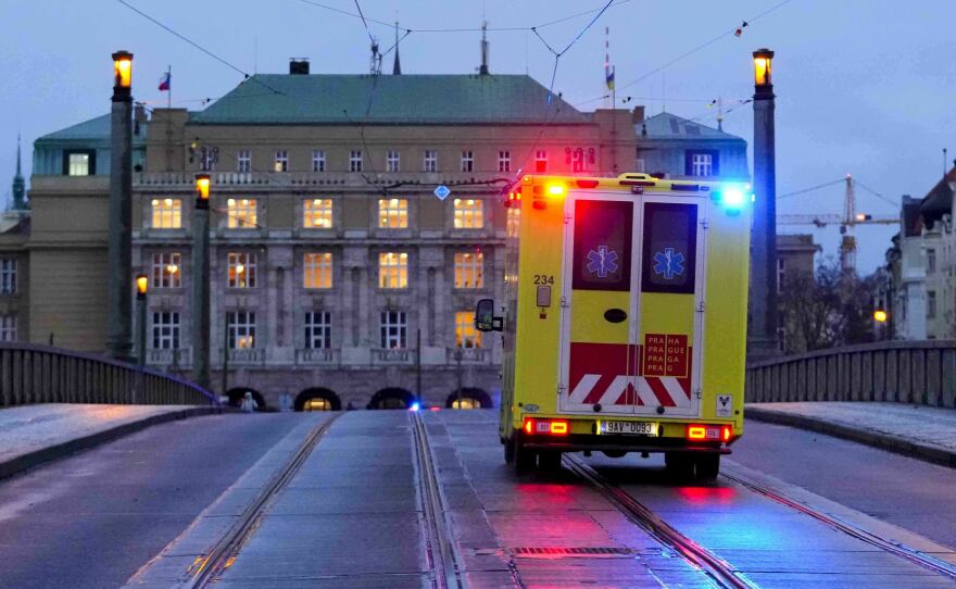 An ambulance drives towards the building of Philosophical Faculty of Charles University in downtown Prague on Thursday after a deadly shooting.