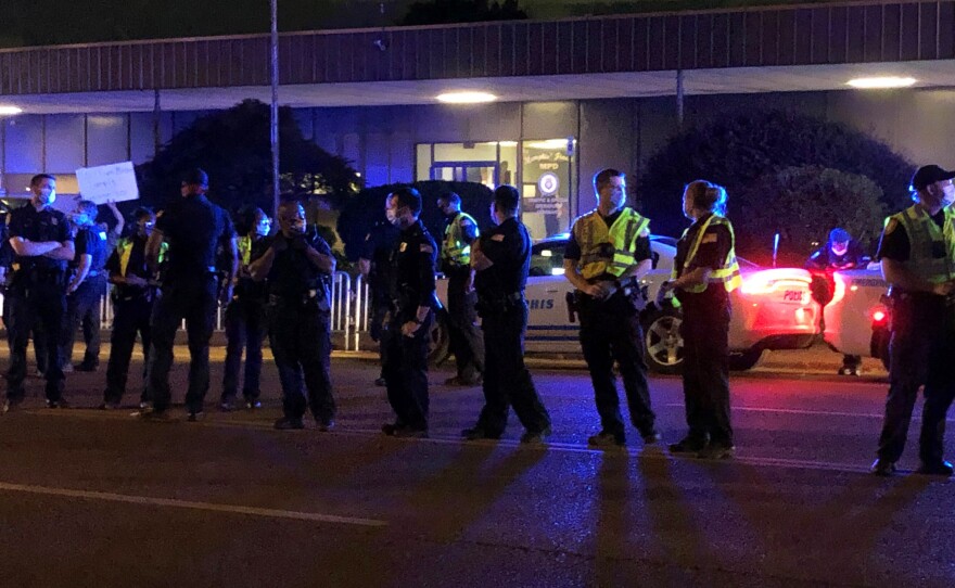 Officers form a line in front of a police precinct May 27, during a protest over the death of George Floyd.