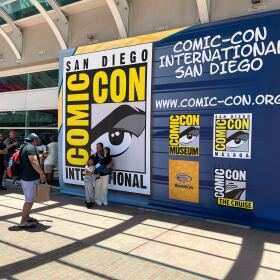 Comic-Con attendees take photos in front of a Comic-Con International sign on July, 23, 2025. 