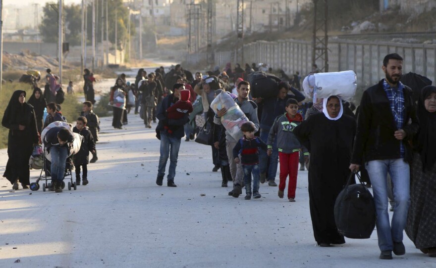 People flee rebel-held eastern neighborhoods of Aleppo on Sunday into the Sheikh Maqsoud area, which is controlled by Kurdish fighters.