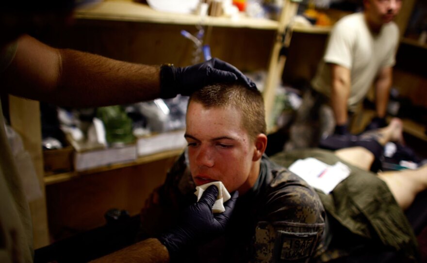 Pvt. Dan Oswald with the 101st Airborne Division's Alpha Company is cared for by medics in an aid station after being hit by shrapnel from a hand grenade in the Zhari district north of Kandahar city, Afghanistan.