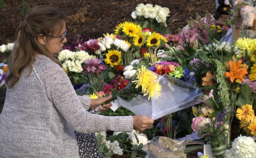 A woman tends to a memorial at Torrey Pines High School, May 8, 2017.