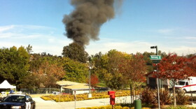 Smoke is seen in Escondido as authorities set fire to a home they said was so packed with homemade explosives that they had no choice but to burn it to the ground.