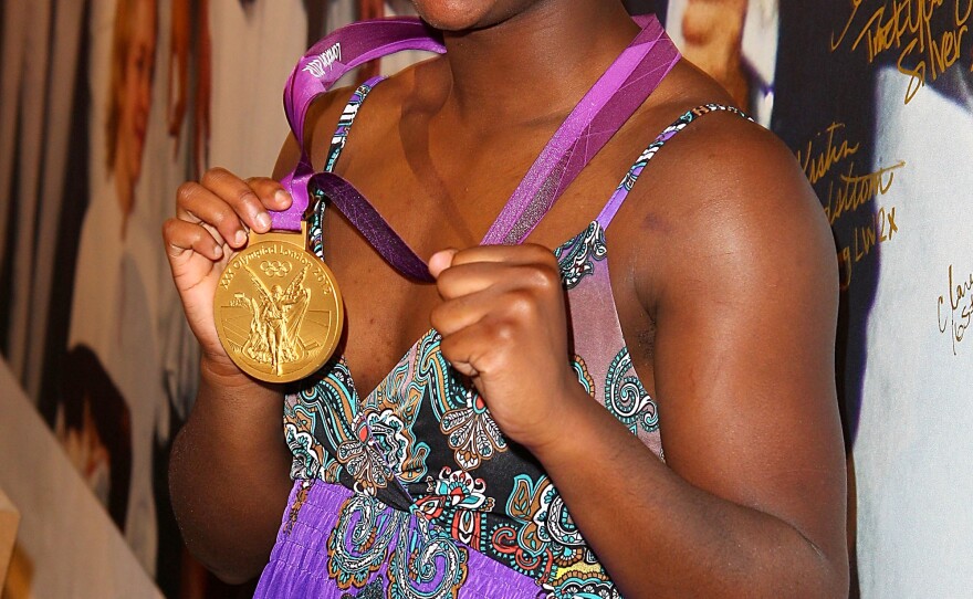Olympian Claressa Shields visits the USA House in London before leaving for her home in Flint, Mich. Shields was greeted by a marching band and a motorcycle escort in her hometown.