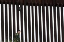 A border patrol agent walks along a border wall separating Tijuana, Mexico, from San Diego in March 2020. The Trump Administration has proposed a number of changes that would restrict asylum claims.