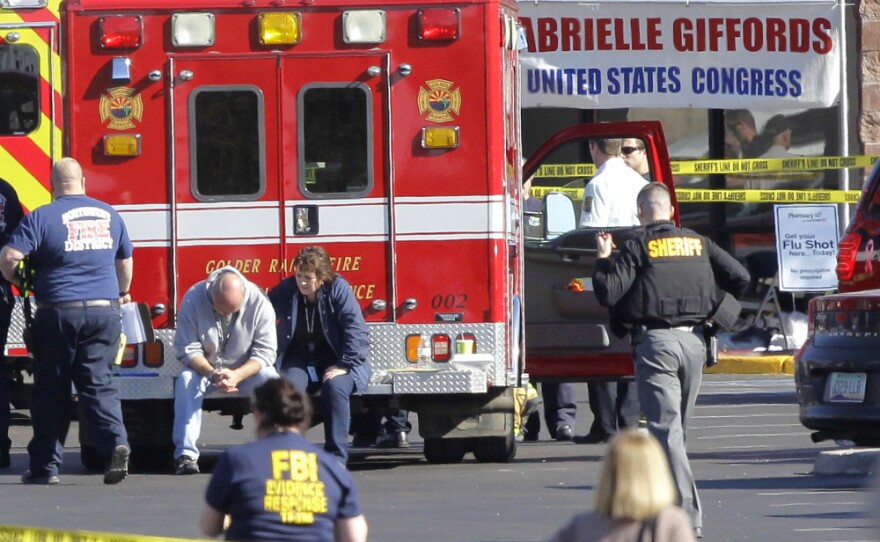 Emergency personnel work on Jan 8 at the scene where Rep. Gabrielle Giffords, (D-AZ) and others were shot outside a Safeway grocery store in Tucson, Ariz. Nearly anyone at the scene that day will be at risk for post traumatic stress disorder, but it's difficult to predict who will be affected.