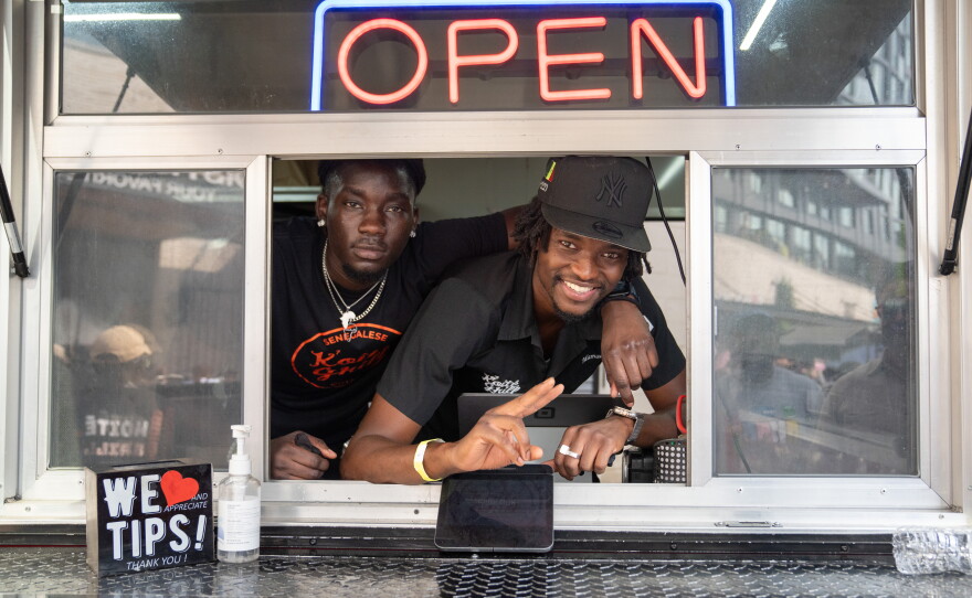 Mamadou Koité (right) and Bai Saine at the window of the Koité Grill food trailer at Union Market, which serves Senegalese and West African food.