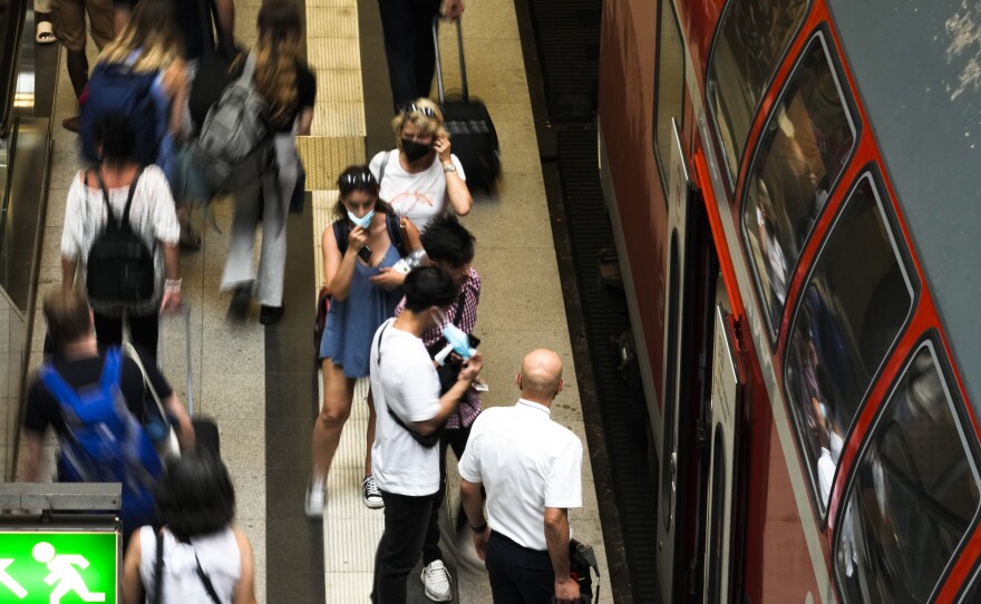 People enters a public transport train at main train station in Berlin, Germany, Sunday, June 19, 2022.