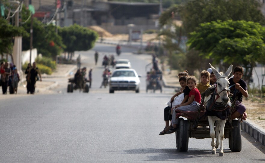 Palestinian families travel to a United Nations school to seek shelter after evacuating their homes near the Israel-Gaza border Sunday. Israel has been warning residents to leave.