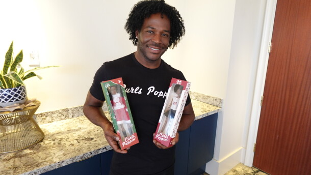 Curls Poppin' CEO Ashley Head holds two Curls Poppin' dolls on Sept. 22, 2026, at the University Club of San Diego.
