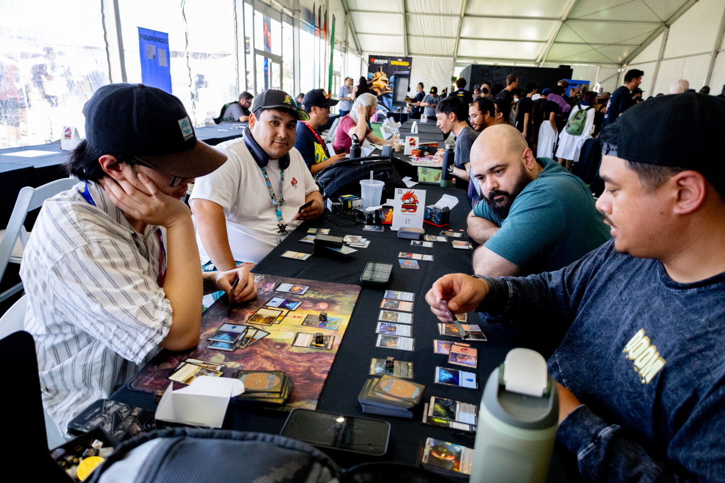 A group of friends play Magic the Gathering in a Magic the Gathering board game pop-up at Comic-Con, April 23, 2026.