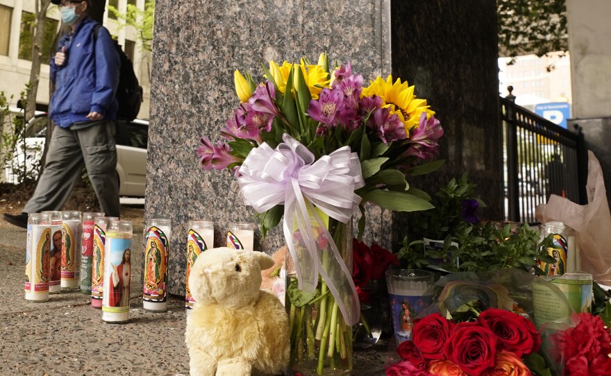 A person passes a memorial near the location of this past weekend's mass shooting in Sacramento, Calif.