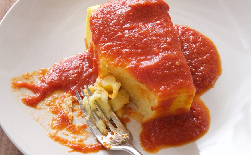 Fluffy baked polenta with a red sauce.