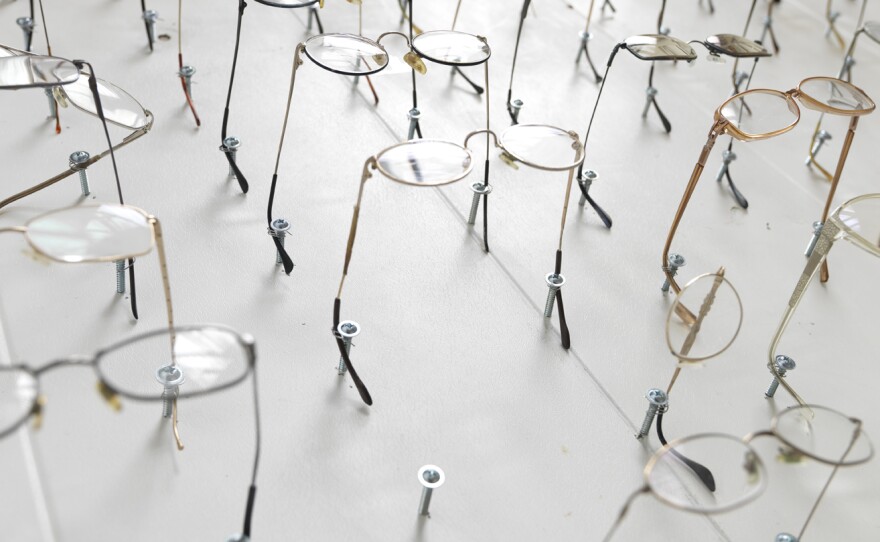 The glasses represent members of the Heaven's Gate religious group. In 1997, 39 members of the group committed mass suicide.