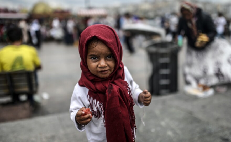 A Syrian refugee child eats food which her mother collected from rubbish at Eminonu in Istanbul.
