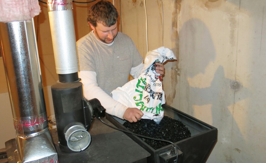 Jesse Ruppert empties a 40-pound bag of local coal into a hopper on top of their new coal-burning furnace. Jamie Ruppert is proud that her home is heated with a resource that is extracted locally. She'd like to have more products made by neighbors who earn good wages, rather than importing items from other countries.