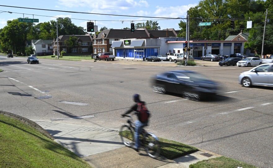 A bicyclist and motorists make their way down Poplar Ave. at the McLean Blvd. intersection on Sept. 8, 2022, in Memphis, Tenn.
